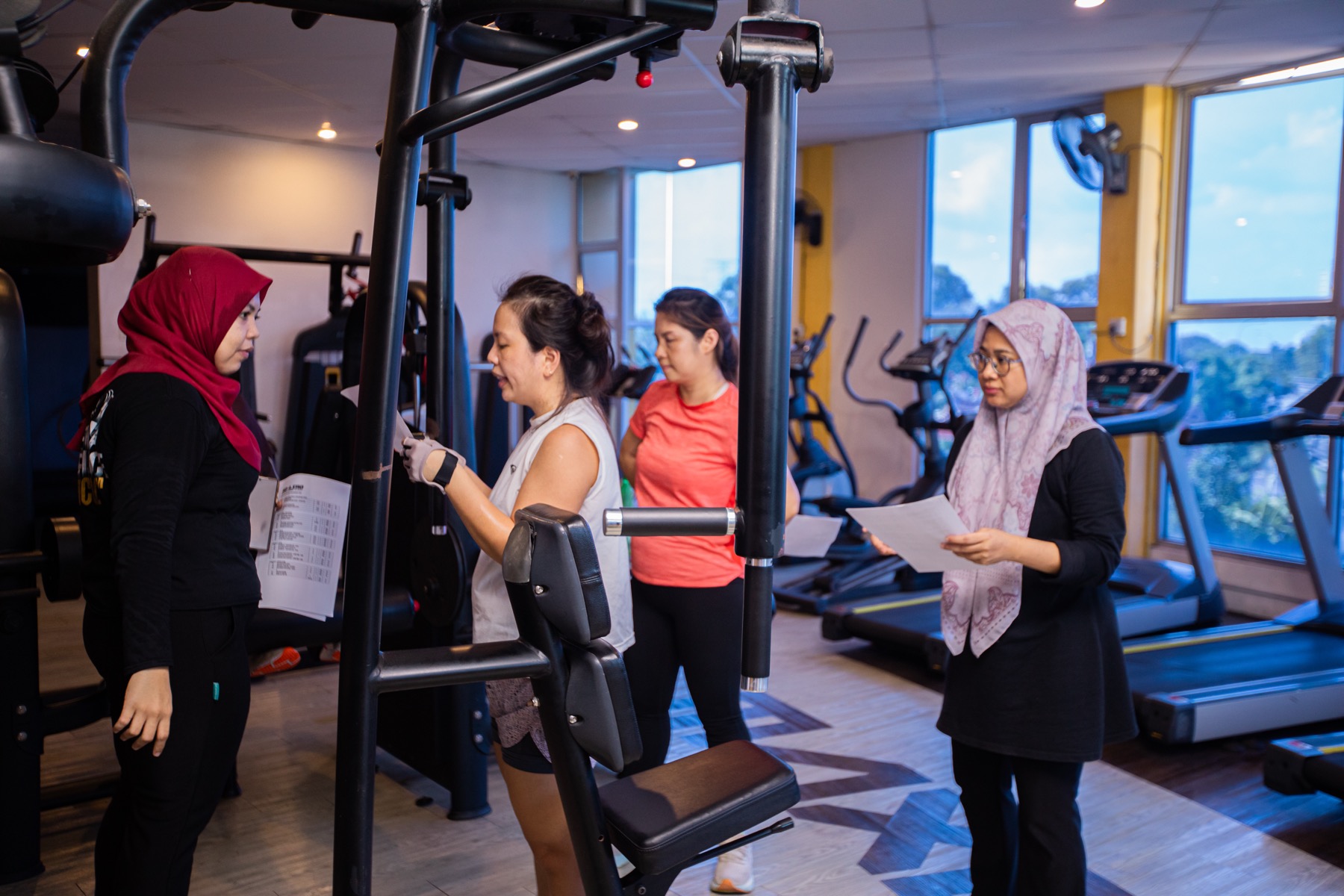 Bootcamp participants reviewing training notes beside strength equipment