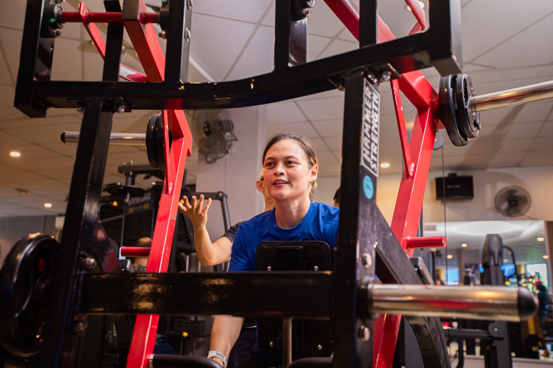 A member using a plate-loaded strength machine during a coached session.