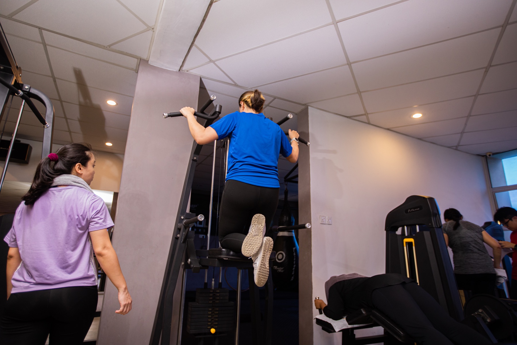 A member training with bodyweight resistance in a coached group session.