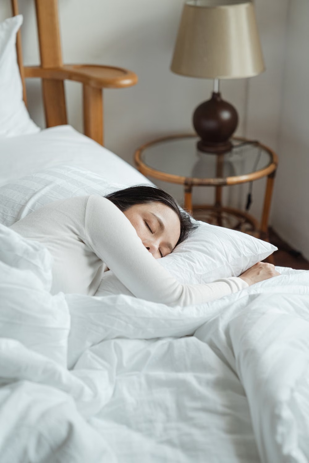 An adult resting in bed in a calm bedroom